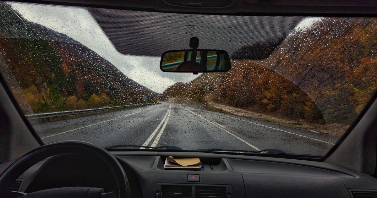 View through a car windscreen on a wet autumn road