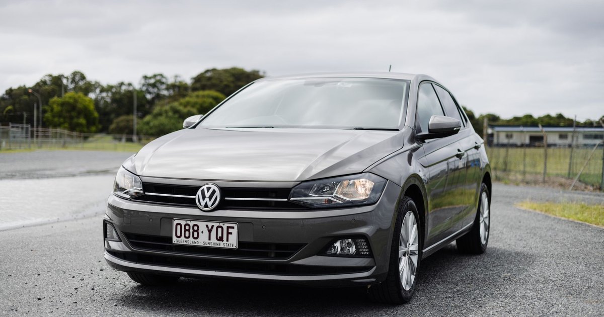 Silver Volkswagen Polo parked on a rural road under overcast skies
