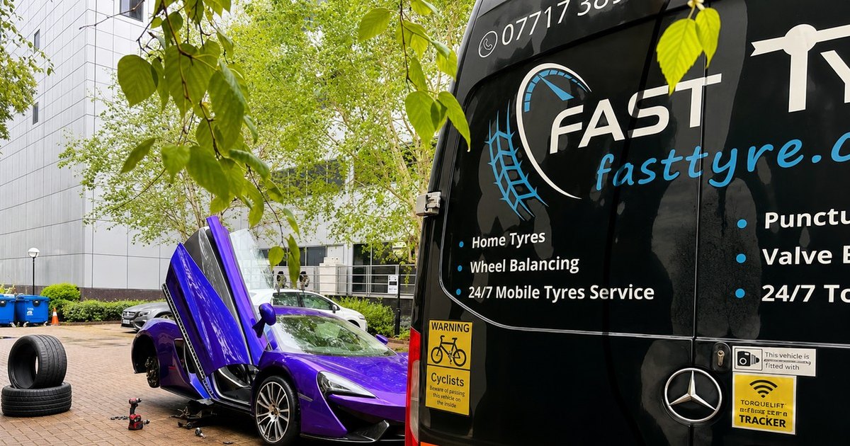 Fast Tyre van with its doors open beside a car having a tyre changed