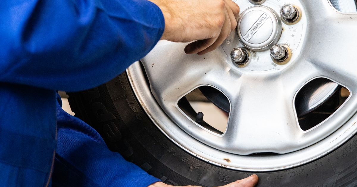 Technician checking a car tyre for MOT-related faults