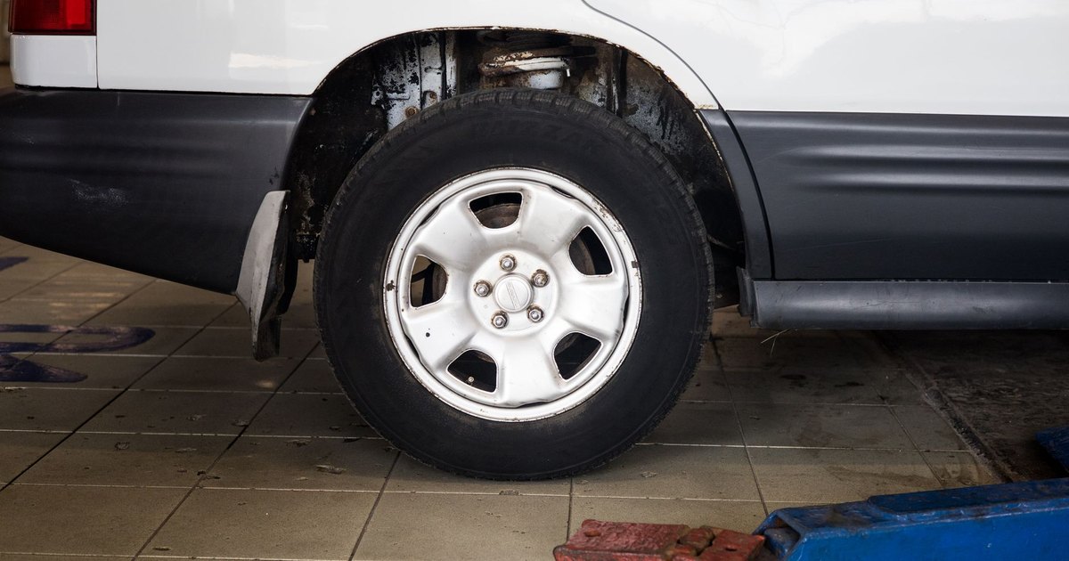 Car wheel being worked on with a hydraulic jack in a repair bay