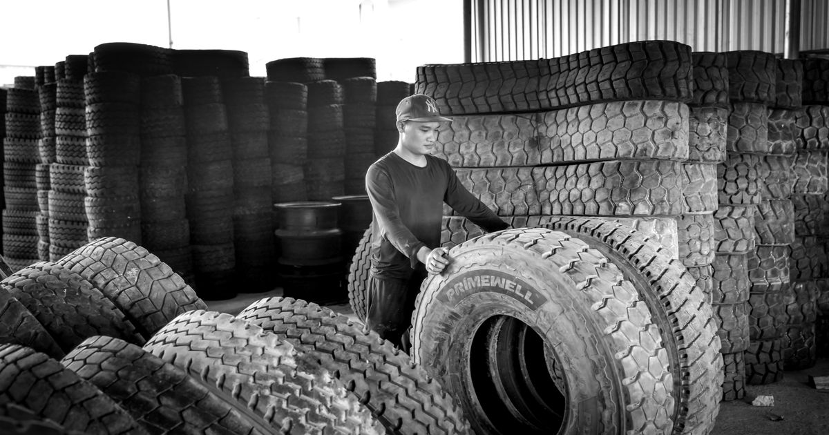 Technician fitting a new tyre to the rear axle of a car, the recommended position for new tyres