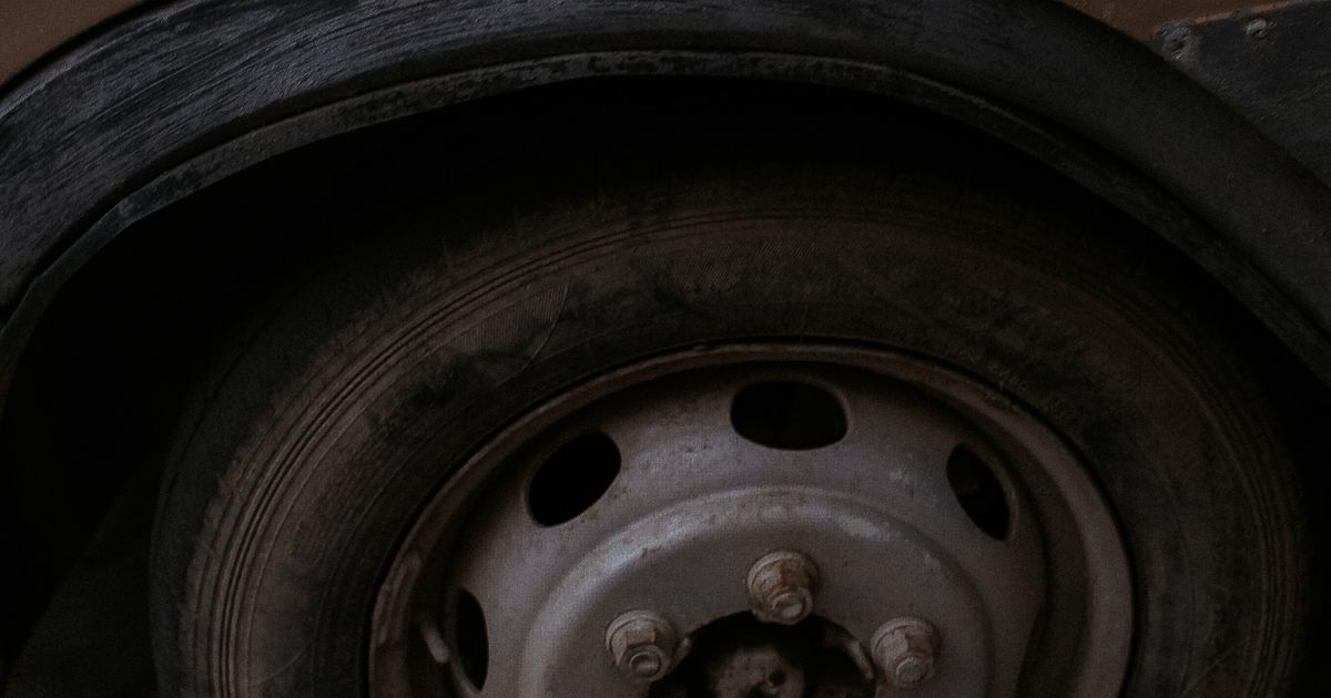 Car with a completely flat tyre pulled over at the roadside