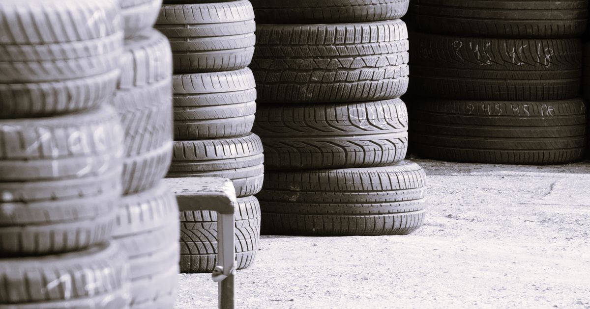 Technician checking tyre pressure on a car wheel, comparing nitrogen and ordinary air inflation