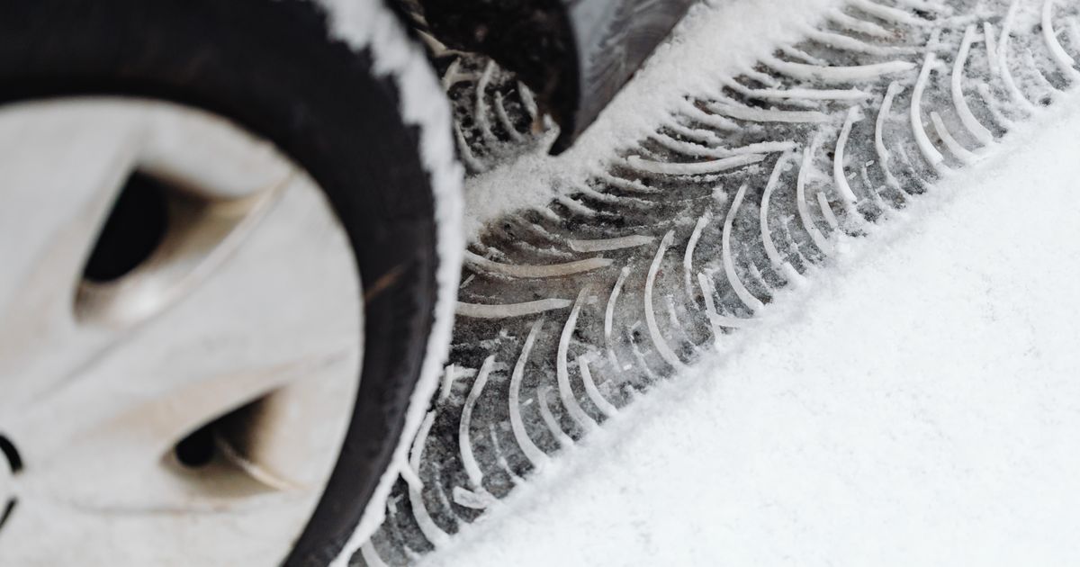 Technician inspecting a car tyre in spring for pothole and winter damage after the cold season