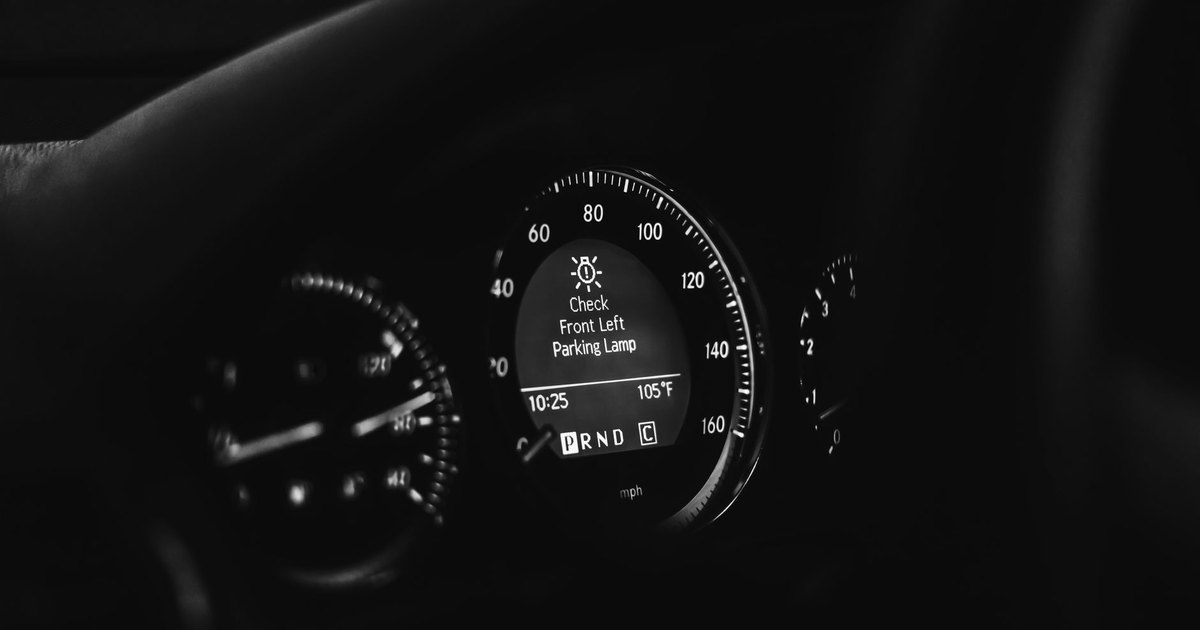 Car dashboard with the speedometer and warning lights lit
