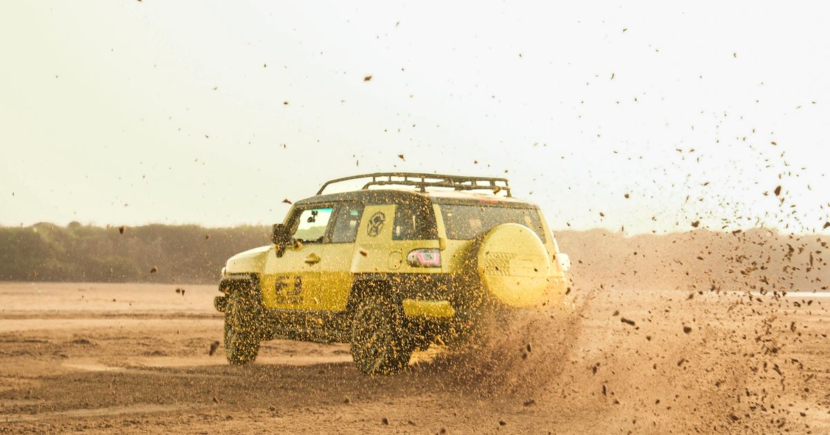 Technician moving a car tyre during a front-to-rear tyre rotation to even out tread wear