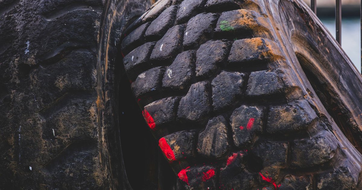 Worn tyres with visible tread and paint marks in an industrial yard