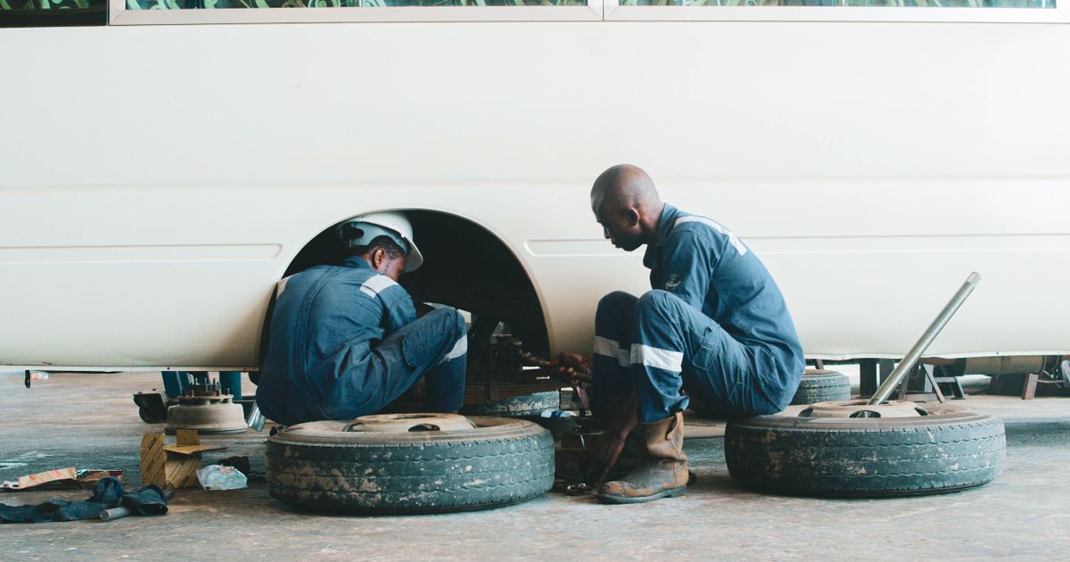 Technician inspecting a car tyre for legal tread depth and damage