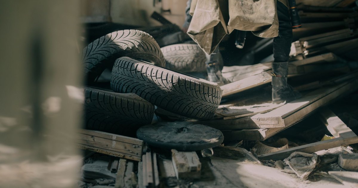 Scattered worn tyres and debris on a workshop floor