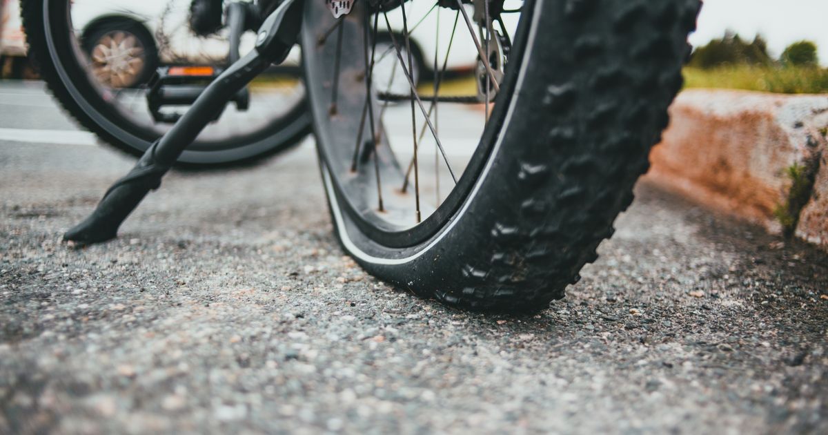 Driver pulled over safely on the verge with hazard lights on after getting a flat tyre