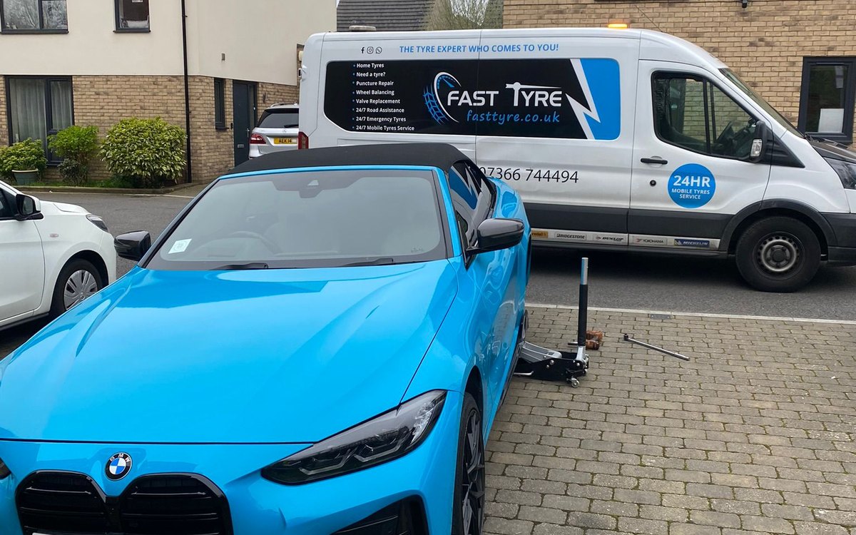 A blue BMW convertible on a driveway with a Fast Tyre van alongside, on a puncture repair callout in Shefford
