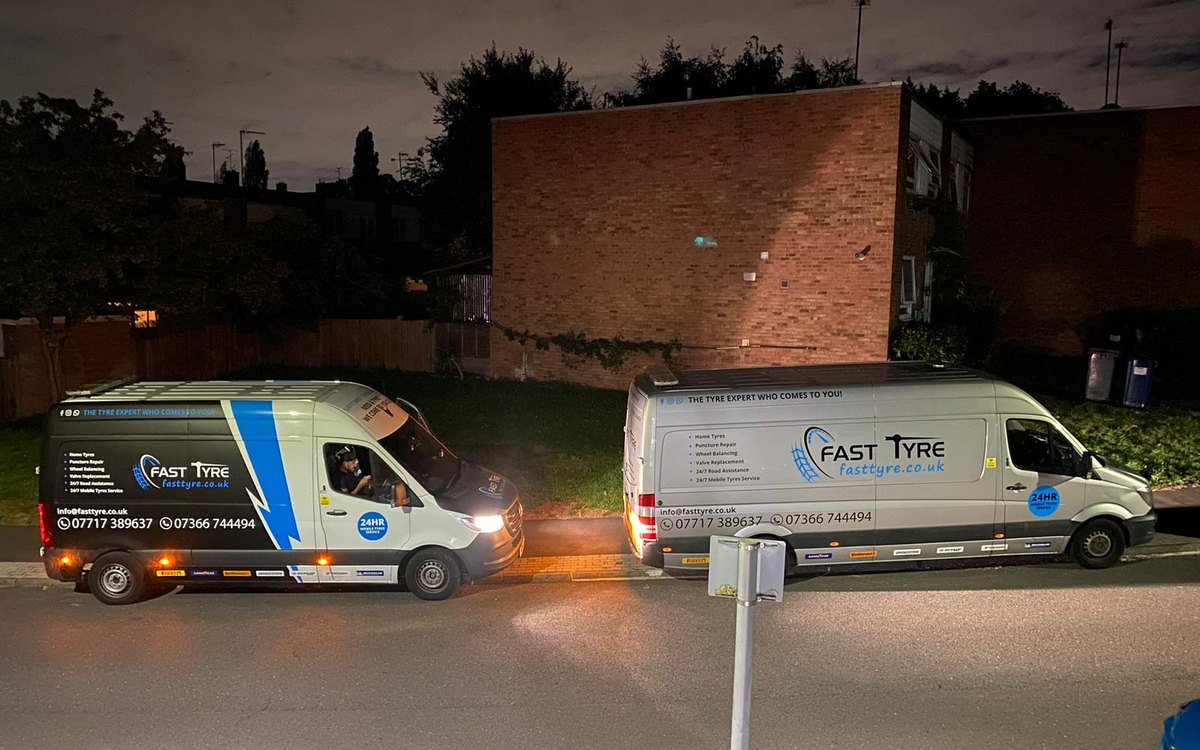 Two Fast Tyre vans at dusk with their lights on, serving Winchmore Hill, Greater London
