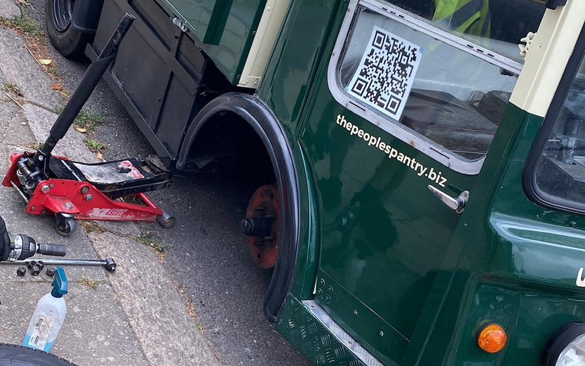 A Fast Tyre engineer working on the wheel of a classic green lorry, serving Windsor, Berkshire