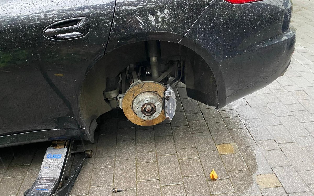 A black SUV with the wheel off and the brake disc exposed